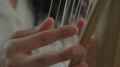 girl-playing-Kora-strings-percussion-African-harp-in-a-warm-daylight-ambient,-close-ups-shot