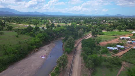 Aerial-flyover-small-village-at-border-to-Haiti-with-river-in-Dajabon