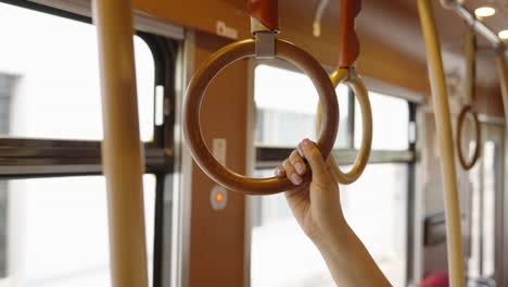 Woman-grabs-onto-round-hanging-handle-on-Kagoshima-tram