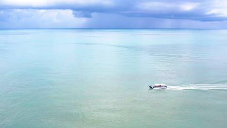 Slow-aerial-tracking-shot-of-a-fishing-boat-travelling-through-the-tropical-sea