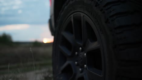 Offroad-Stopped-Van-Car-Wheel-Close-up-Against-Sunset---revealing-shot