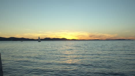 Sensational-sunset-view-from-Zadar-in-Croatia,-sailboat-on-distance,-static