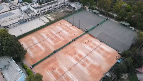 4K-Drone-Shots-of-a-Lawn-Tennis-Ground-during-Sunset-in-an-Indian-City-New-Delhi-above-trees-and-houses-beautiful-light-punjabi-bagh-club-posh-colony