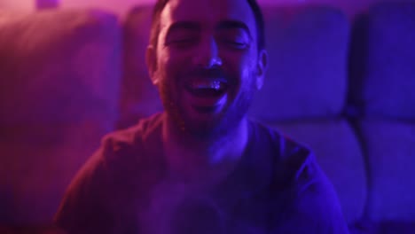 Man-laughing-evilly-with-red-and-blue-lit-up-smoke-surrounding-him