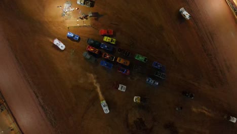 Cars-line-up-to-exit-infield-of-oval-dirt-track-race---aerial-overhead-shot