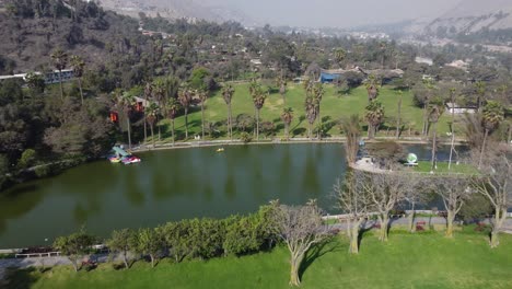 Drone-video-of-a-lake-surrounded-by-green-grass-and-trees