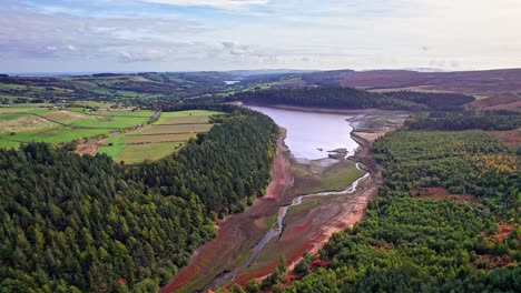 Aerial-footage-flying-over-woodland-and-Langsett-Reservoir,-Yorkshire