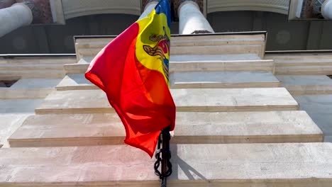 Moldovan-flag-hanging-on-facade-of-historic-building,-low-angle-shot