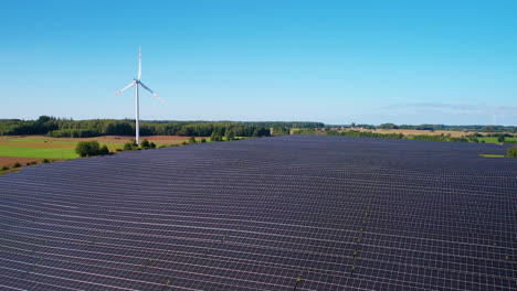Solar-Energy-Panels-And-Wind-Turbine-In-Summer-Landscape---aerial-drone-shot