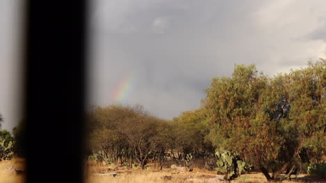 A-sunset-in-the-desert-with-a-rainbow-that-connects-with-the-earth,-with-hope-and-remembers-who-we-are