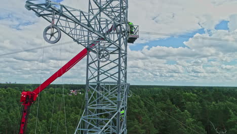 Drone-flying-close-to-high-voltage-pylon-while-maintenance-workers-work-in-rural-landscape