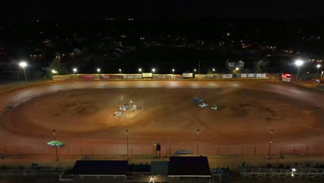 aerial-flyaway-shot-of-dirt-track-car-racing-at-night