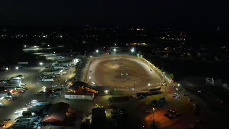 Multiple-aerial-orbits-of-oval-dirt-race-track-racing-at-night