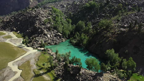 Cinematic-drone-shot-of-turquoise-colored-water-in-the-mountains-at-Naltar-Valley-in-Pakistan,-slow-descending-towards-lake,-aerial-shot