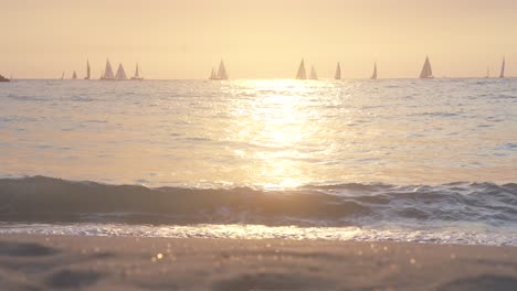 Goldene-Stunde-Am-Venedig-Strand-Von-Los-Angeles,-Segelboot-Segeln-Am-Ozean,-Die-Wellen-Und-Der-Sand-Werden-Vom-Sonnenuntergang-Golden-Beleuchtet,-Zeitlupe