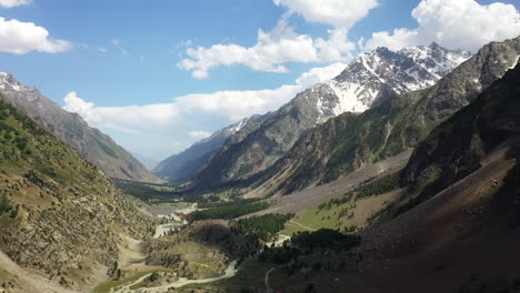 Aerial-shot-of-the-mountains-valley-and-clouds-at-Naltar-Valley-in-Pakistan,-revealing-drone-shot