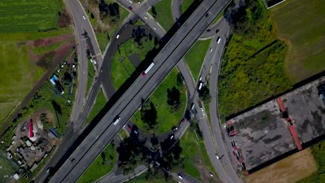 Top-Drohne-Blick-Auf-Eine-Kleeblatt-Kreuzung-Auf-Einer-Kleinen-Autobahn-In-Der-Charmanten-Stadt-Chalco,-Mexiko