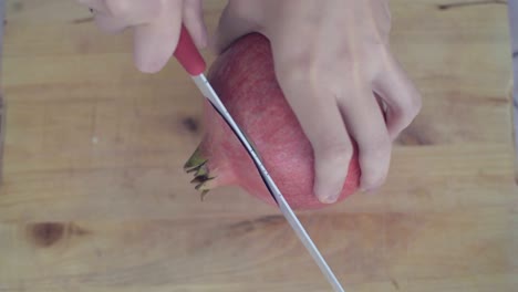 Cutting-off-the-top-of-pomegranate-with-the-knife
