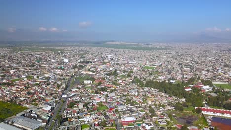 Top-drone-view-of-downtown-the-charming-town-of-chalco-Mexico,-and-view-of-the-downtown-and-roads-towards-Mexico-City