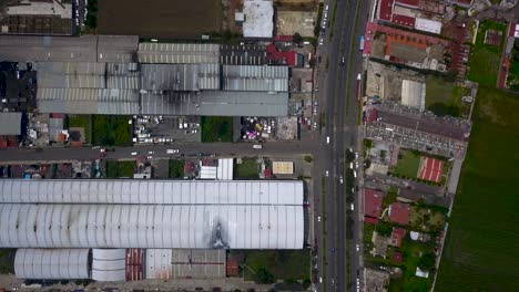 Top-view-of-warehouses-in-the-industrial-park-of-the-town-of-chalco,-Mexico-with-a-view-of-the-roads-and-traffic