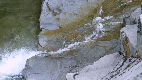 Coho-Lachs-Springt-Einen-Kleinen-Wasserfall-Hoch,-Der-über-Felsen-Fließt,-Und-Fällt-Zurück-In-Den-Pool