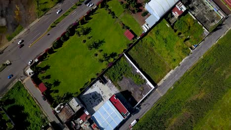 An-aerial-view-of-a-green-flied-and-reveal-of-the-traffic-and-the-little-charming-city-of-chalco-in-Mexico
