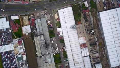 Top-view-of-warehouses-in-the-industrial-park-of-the-town-of-chalco,-Mexico-with-a-view-of-the-roads-and-traffic