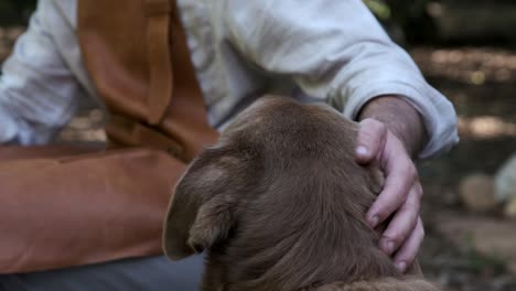Mann-In-Einer-Lederschürze-Streichelt-Seinen-Braunen-Labrador-Hund