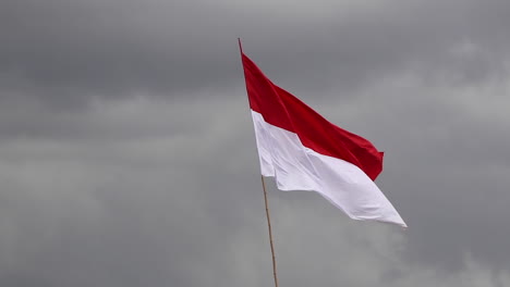 Merah-Putih,-Indonesische-Flagge,-Die-Im-Wind-Gegen-Dunkle-Wolken-Flattert