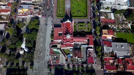 Top-drone-view-of-a-catholic-church-in-the-charming-town-of-chalco-Mexico,-and-view-of-the-downtown-and-roads-towards-Mexico-City