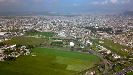 Vista-Superior-De-Drones-De-Un-Campo-De-Fútbol-En-La-Encantadora-Ciudad-De-Chalco-Mexico,-Y-Vista-De-La-Ciudad-De-La-Carretera-Y-La-Densidad-De-Población-De-Las-Casas