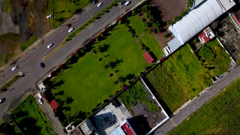 Top-drone-view-of-a-soccer-field-in-the-charming-town-of-chalco-Mexico,-and-view-of-the-highway-town-and-houses-population-density
