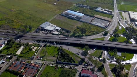 Vista-Superior-De-Drones-De-Un-Intercambio-De-Hojas-De-Trébol-En-Una-Pequeña-Carretera-En-La-Encantadora-Ciudad-De-Chalco-México