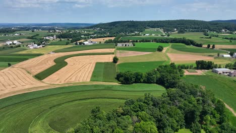 An-aerial-view-over-the-lush-green-farmland-in-southern-Lancaster-County,-Pennsylvania-on-a-sunny-summer-day