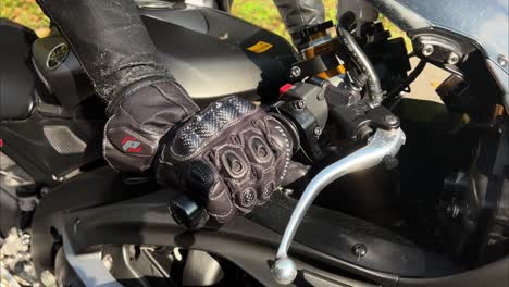 Close-up-shot-of-male-hand-in-gloves-twisting-the-throttle-grip-and-revving-the-engine-of-a-motorcycle