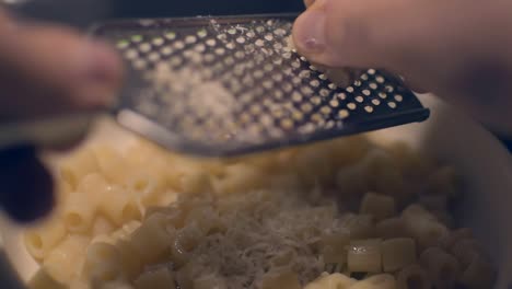 Grattuggiare-formaggio-sulla-pasta.-Grating-cheese-on-pasta