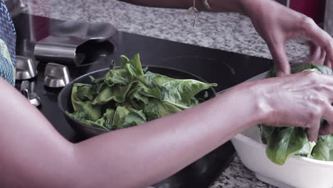 Woman-cooking-Spinach-is-a-skillet