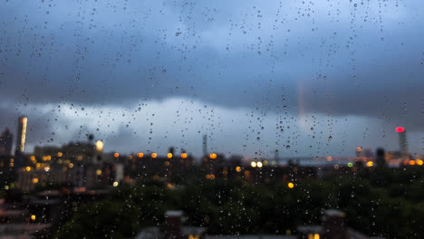 Regentropfen-Sammeln-Sich-Auf-Der-Fensterscheibe,-Während-Die-Abendlichter-Von-New-York-City-Im-Hintergrund-Auftauchen