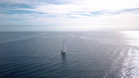 Aerial-footage-panning-around-luxury-yacht-sailing-slowly-in-deep-blue-open