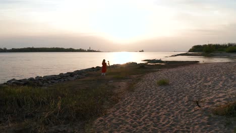 Young-girl-taking-photos-at-sunset-near-sea-gates