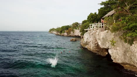 Boy-jumps-of-Kalikasan-Cliff-Jump-into-deep-blue-tropical-water-on-Panglao-Island-in-the-Phillipines
