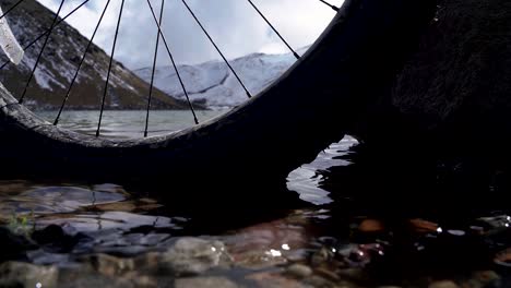 Close-up-the-calm-water,-rocks-and-a-bicycle-wheel-in-the-main-lagoon-xinantecatl-volcano-in-Mexico,-this-is-a-tourist-location-in-the-beautiful-nevado-de-toluca-mountain