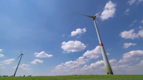 Blue-skies-and-white-fluffy-clouds-above-the-green-fields-and-wind-turbines-somewhere-in-Germany