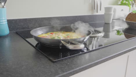 Panning-shot-of-omelet-cooking-in-a-skillet-with-extraction-system