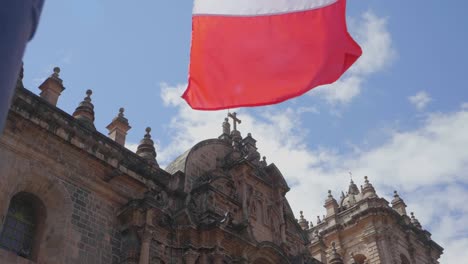 Slow-motion-footage-of-the-cathedral-of-Cusco,-Peru,-with-waving-flags