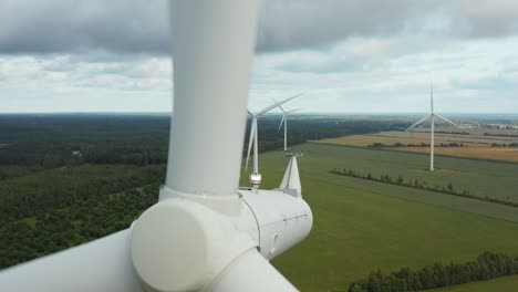 Close-up-of-a-rotating-wind-turbine-with-wind-turbine-park-in-the-background