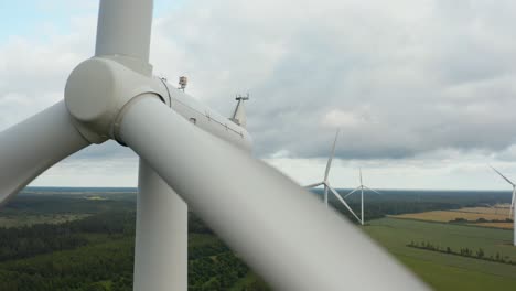 Einzigartige-Nahaufnahme-Einer-Rotierenden-Windkraftanlage-Mit-Windkraftanlage-Im-Hintergrund