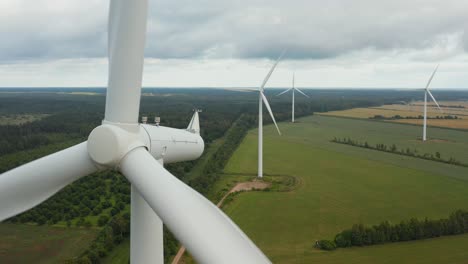 Close-up-of-a-rotating-wind-turbine-with-wind-turbine-park-in-the-background