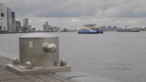 Slow-motion-focus-shot-of-a-bollard-at-the-IJ-in-Amsterdam-with-a-ferry-in-the-background