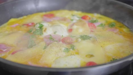 Omelet-with-cheese-and-vegetables-baking-in-a-skillet